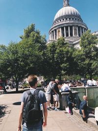 Rear view of people against building in city