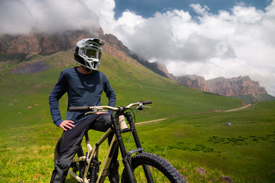 Rear view of man riding bicycle on mountain