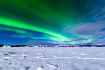 Scenic view of snowcapped landscape against sky at night