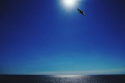 Low angle view of sea against clear blue sky