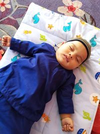 High angle view of baby lying on bed