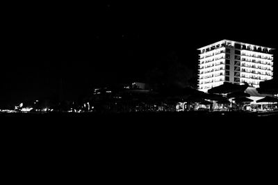 Illuminated buildings against sky at night