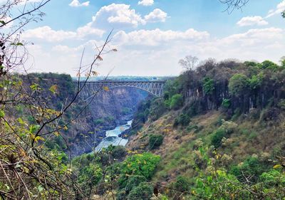 Scenic view of bridge over river against cloudy sky