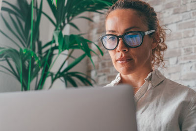 Young woman using laptop while sitting on table