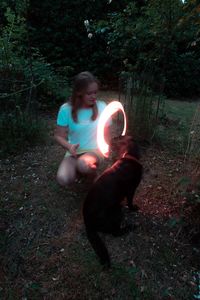 Woman with dog sitting on land