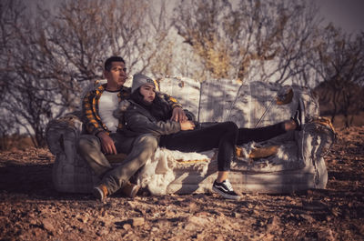 Young man sitting on land