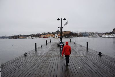 Rear view of person walking on pier