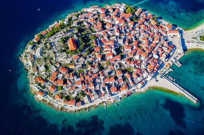 High angle view of illuminated city by sea