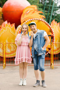 Happy couple in love having fun in an amusement park, eating lollipops person