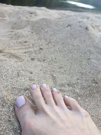 Low section of person on sand at beach