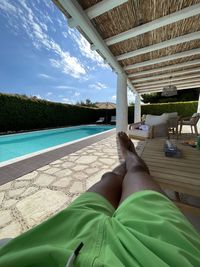 Low section of man relaxing in swimming pool