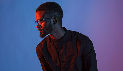 Thoughtful man against colored background