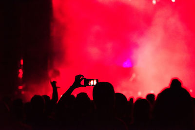 Silhouette people photographing at music concert