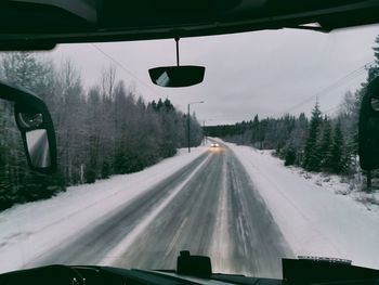 Snow covered road seen through car windshield