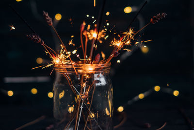 Close-up of illuminated sparklers in jar at night