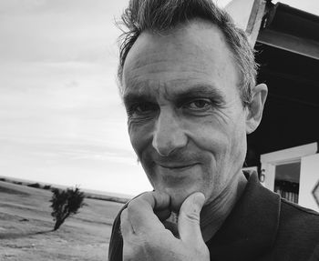 Portrait of smiling mid adult man against sky