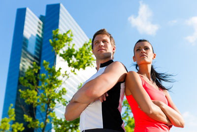 Low angle view of friends wearing sports clothing standing outdoors