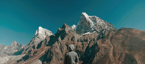 Panoramic view of snowcapped mountains against clear blue sky