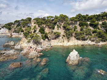 Rock formations by sea against sky