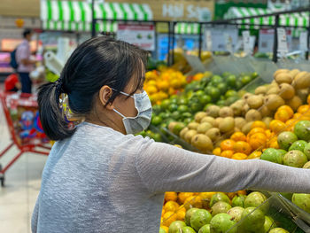 Midsection of woman with fruits at market stall