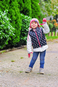 Portrait of girl sticking out tongue while standing on footpath