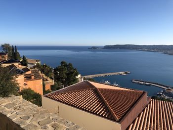 High angle view of houses by sea against clear sky