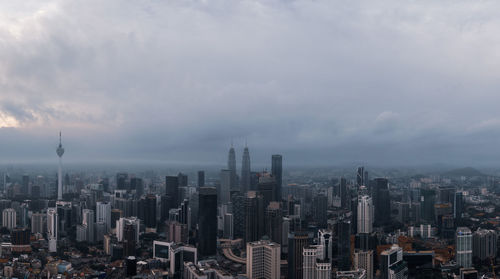 Aerial view of buildings in city against sky