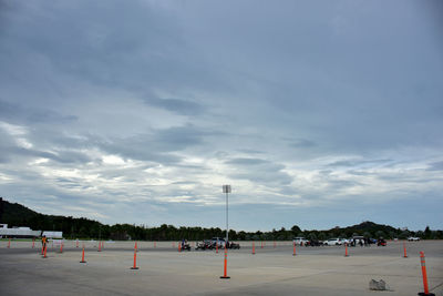 People playing soccer field against sky