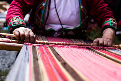 Midsection of woman weaving alpaca wool