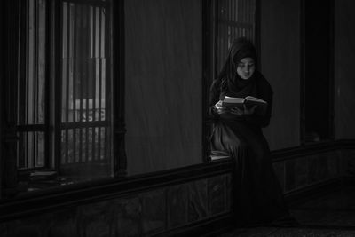 Woman looking at camera while sitting at home