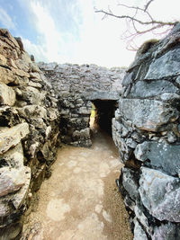 Narrow footpath amidst rocks against wall