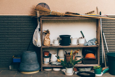 Cleaning equipment and potted plants on old cabinet against wall