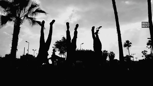 Low angle view of silhouette trees against cloudy sky