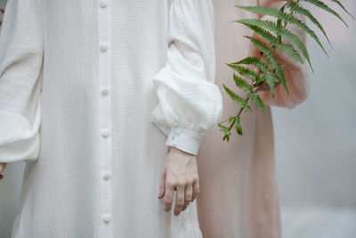 Midsection of women standing with plant