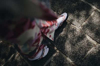 Low section of woman standing on footpath