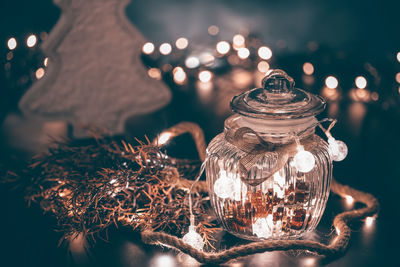 Glass jar with christmas ornaments on table