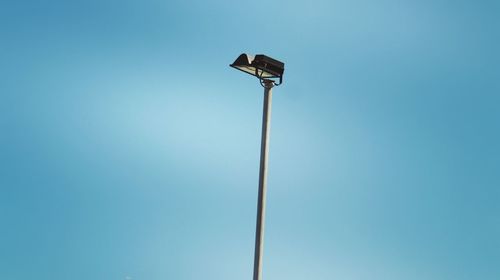 Low angle view of street light against blue sky