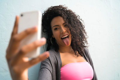 Portrait of smiling young woman using mobile phone