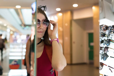 Reflection of woman wearing sunglasses at store