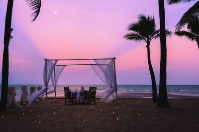 Decorated beach against dramatic sky during sunset