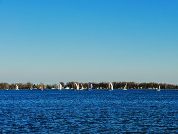Scenic view of lake against clear blue sky