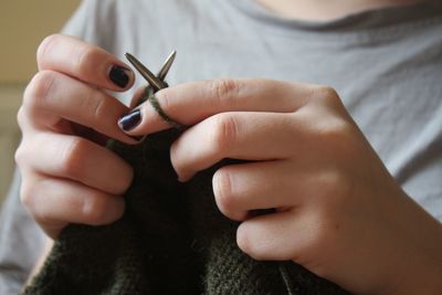 Midsection of woman knitting wool