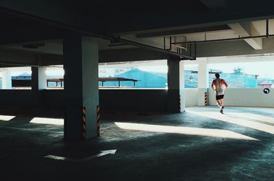 Rear view of man jogging in parking lot