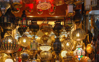 Illuminated lanterns hanging in market stall