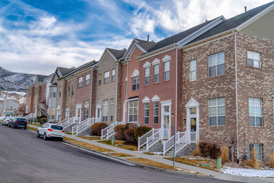 Street by buildings against sky