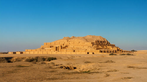 Built structure on desert against blue sky