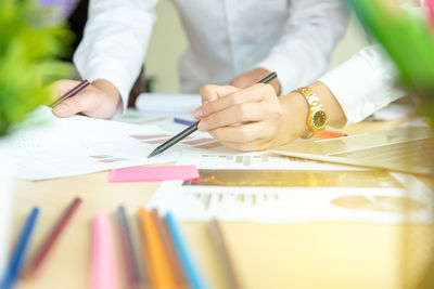 Cropped hands of business coworkers working in office