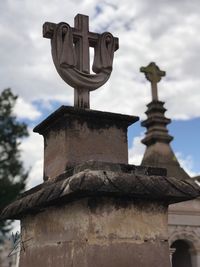 Low angle view of cross sculpture against sky