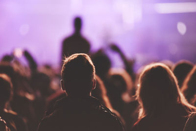 Silhouette people at music concert against sky at night