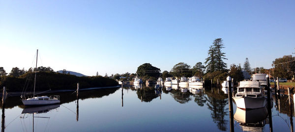 Boats moored in lake against clear sky